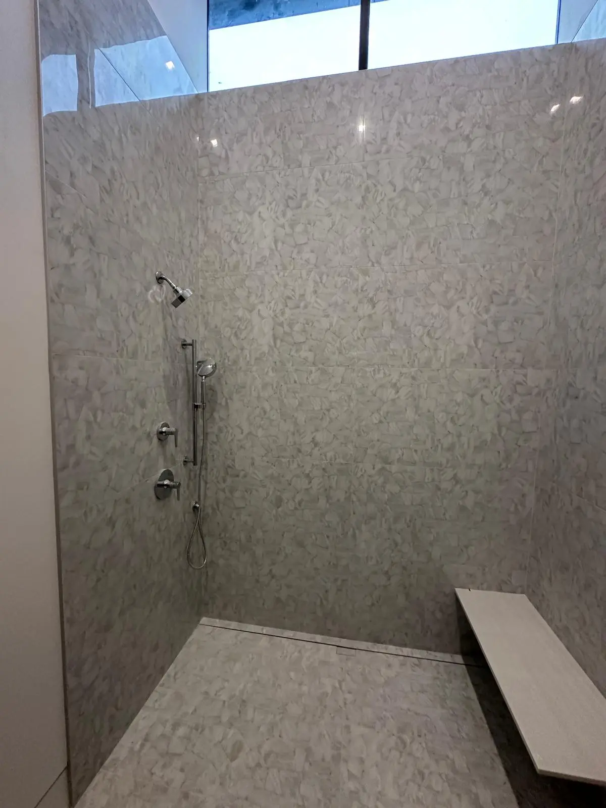 Walk-in shower tile work with frameless glass enclosure